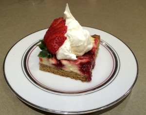 Plated Strawberry Swirl Cheesecake with strawberry and and whipped cream