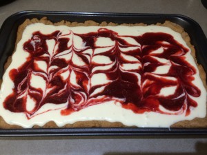 Strawberry Jam swirled into cheesecake batter before baked.