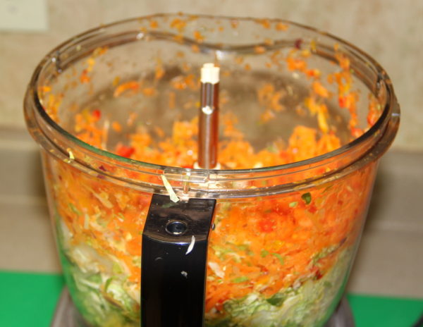Adding extra shredded carrots and sweet peppers to mixture.