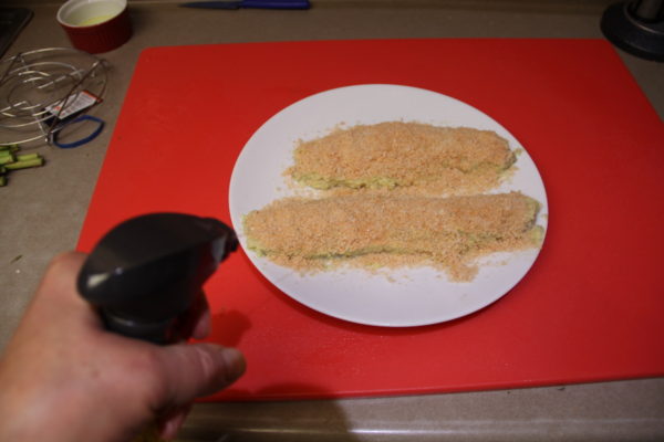 Spray canola oil onto fish filets.