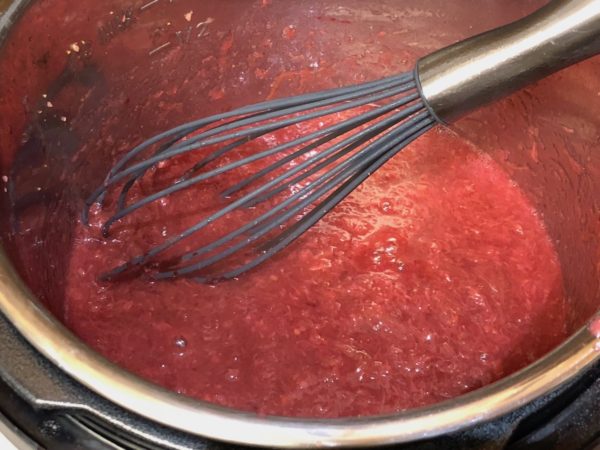 Adjusting Strawberry Rhubarb Sauce with sweeteners.