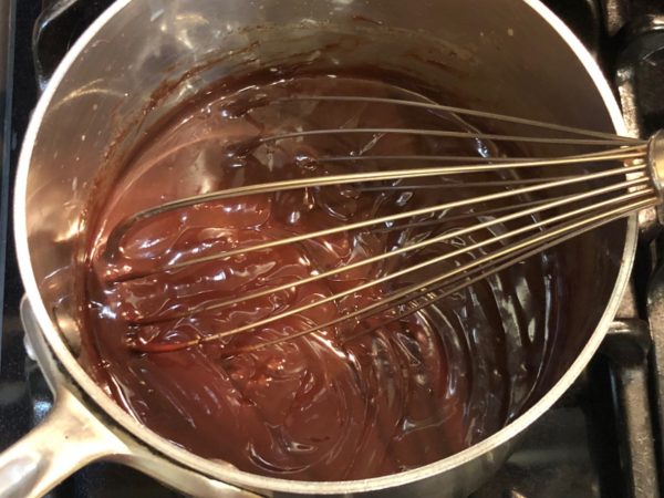 Stirring dark chocolate into cooked minted milk.