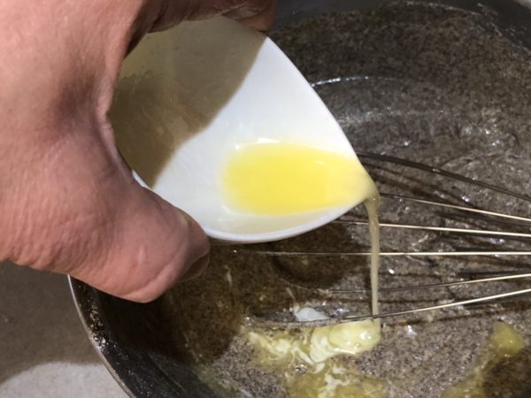 Adding the melted butter into the crepes batter.
