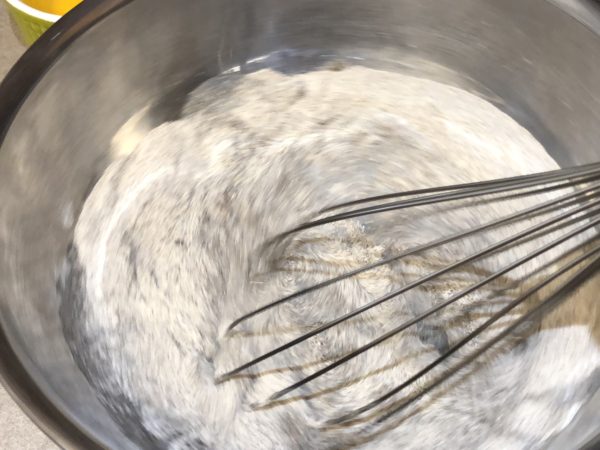 Whisking dry ingredients together until combined.
