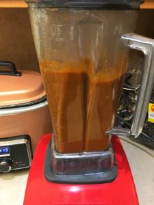 Blending chilies and garlic with chili stock.