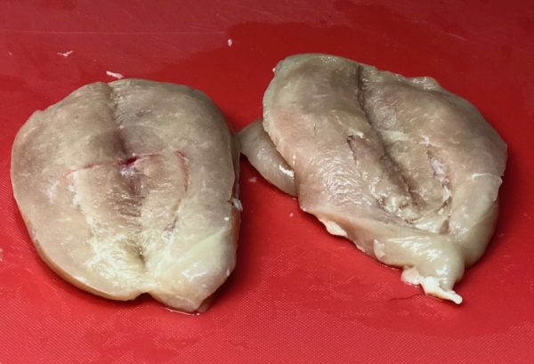 Trim and butterfly chicken breast with boning knife
