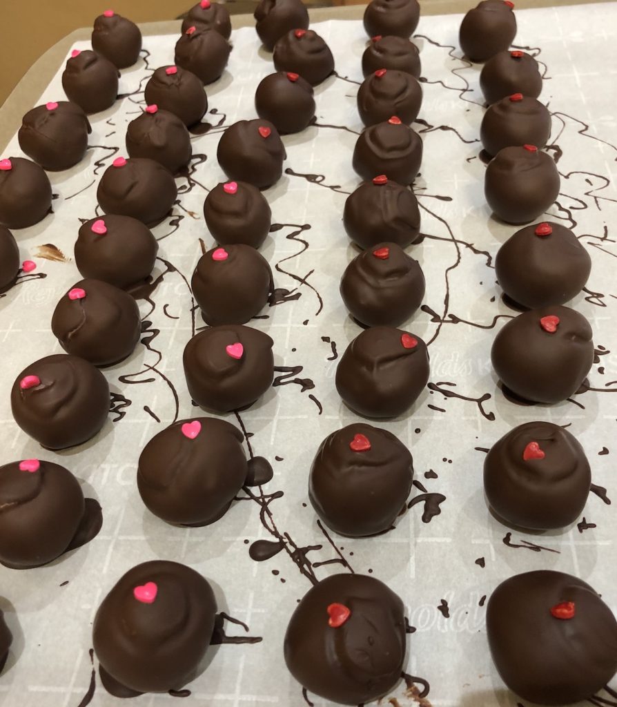 Hand dipped Raspberry Chambord and Cinnamon Truffles on parchment paper.
