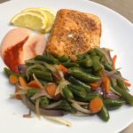 Garnished Spicy Air Fryer Salmon with sautéed green beans mix and Spicy Ranch Dressing